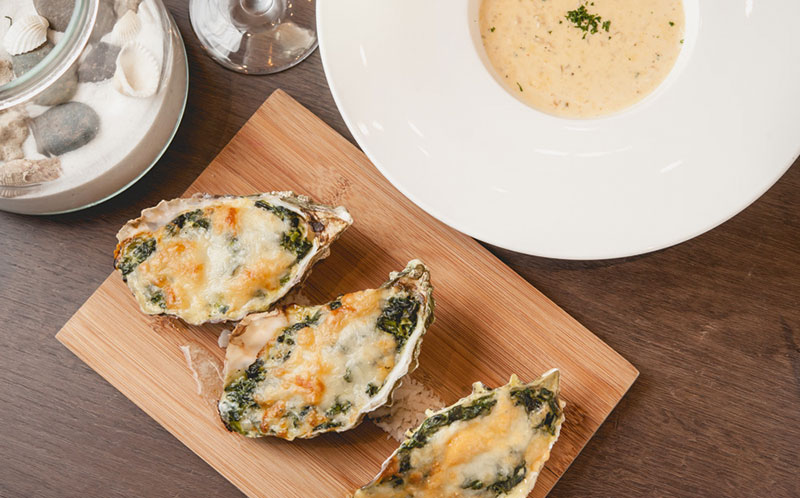 ランチセットより 「OYSTER ROCKE FELLER」 ฿350++ 牡蠣とほうれん草のグ ラタン、クラムチャウダー、グラスワイン(白)のセット